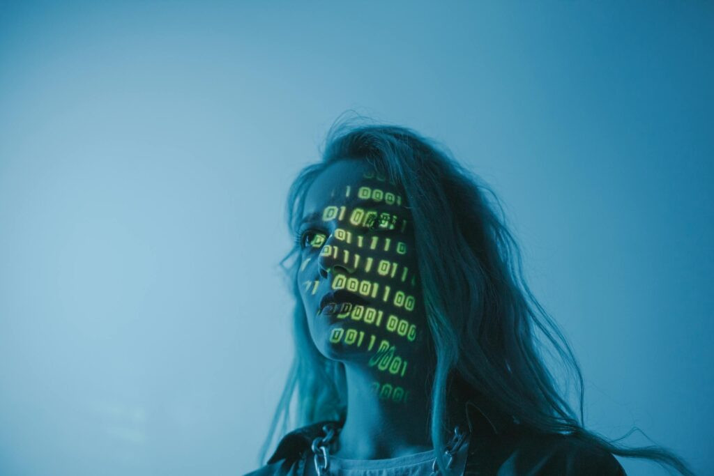 AI Coding Assistants Developers Actually Need in 2025: A Practical, Honest Breakdown 20 A woman with binary code lights projected on her face, symbolizing technology.