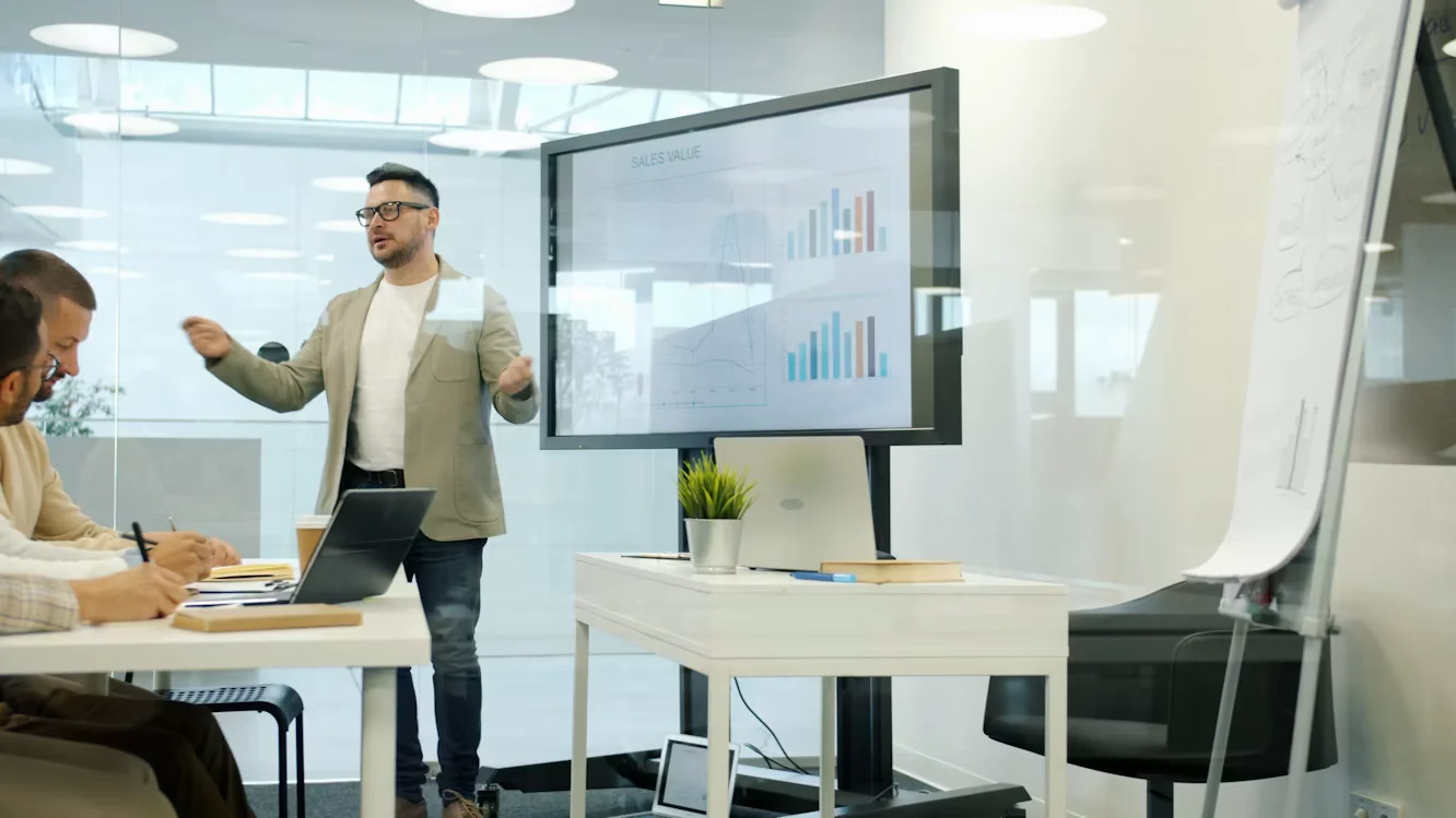 man presenting data on large screen
